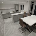 A dining area styled with Chatsworth Grey flooring, featuring a beautifully set table and a centerpiece of an intricately designed cake. The grey flooring complements the elegant and refined atmosphere.