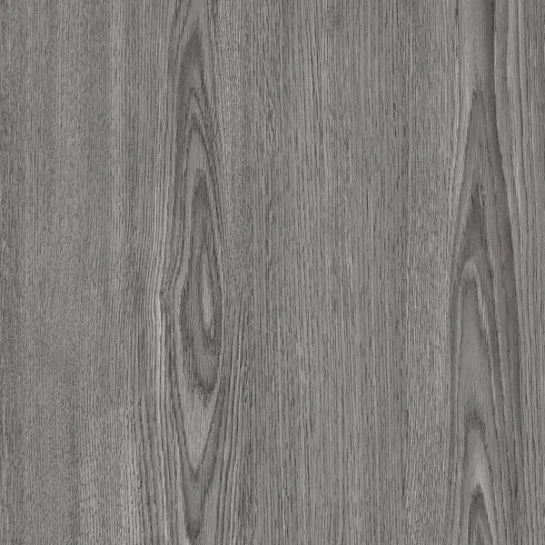 A macro shot focusing on the edge of a single Pro-Tek™ flooring plank, showing the finely cut profile designed for easy installation. The high-resolution image reveals the layers of the plank, including its rigid core structure and protective wear layer, which contributes to its durability.